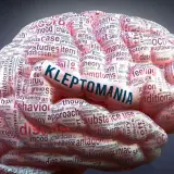 Mózg wypełniony słowami, z napisem "KLEPTOMANIA" na środku. Obraz symbolizuje zaburzenie, jakim jest kleptomania.