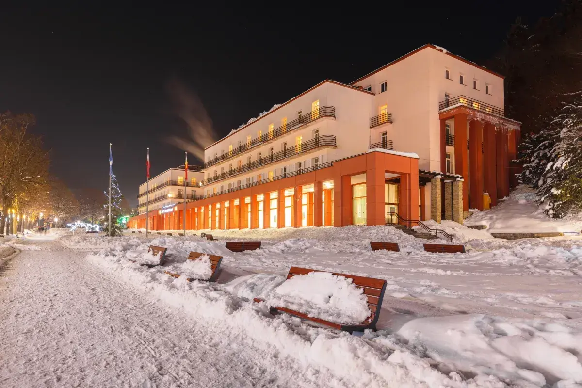 Zimowy wieczór przed sanatorium. Warto sprawdzić nowe zasady wyjazdu do sanatorium na NFZ, by cieszyć się wypoczynkiem.